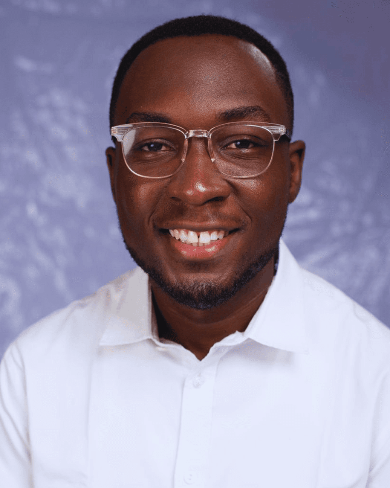 Emmanuel wearing glasses and a white shirt
